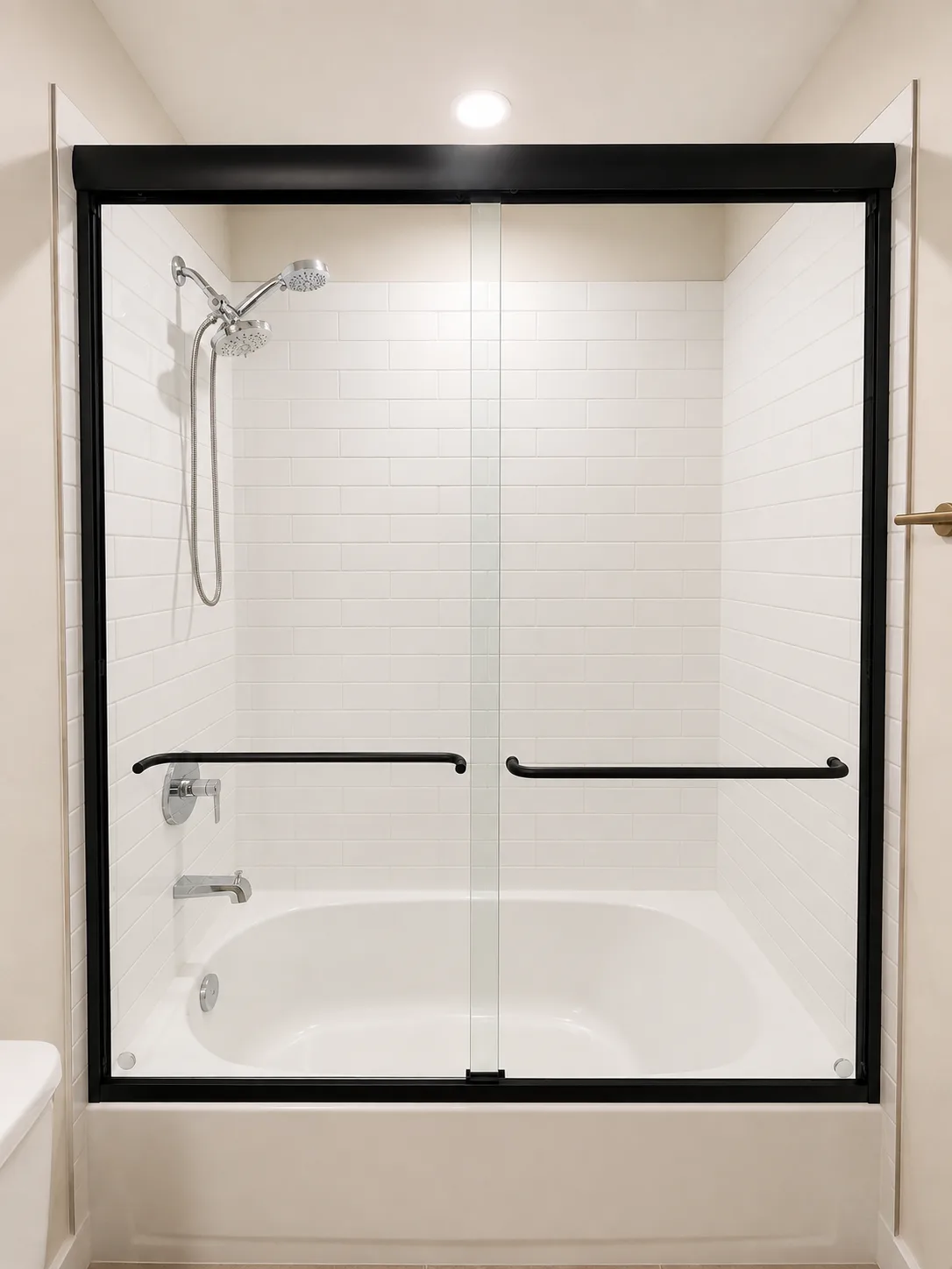 Semi-frameless Opal double-sliding shower door with matte black framing over a white bathtub with subway tile in a Sarasota bathroom